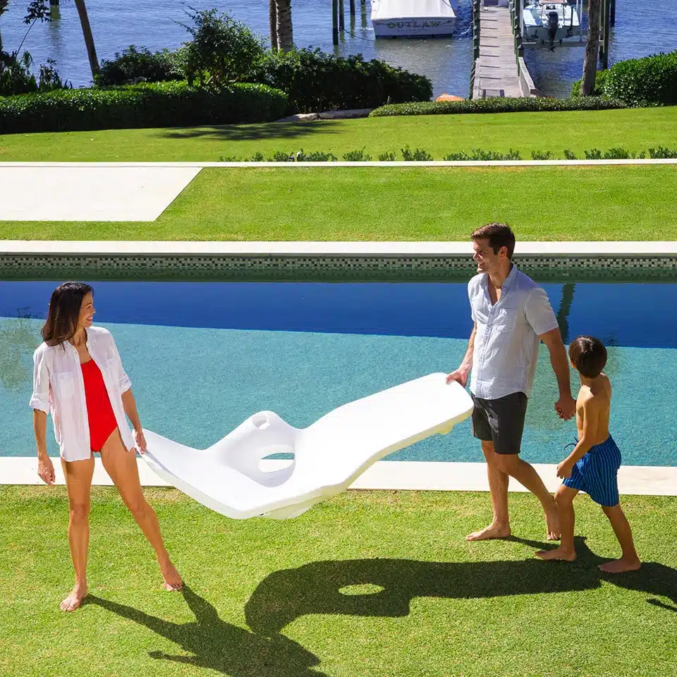 Couple Carrying White Pool Lounger