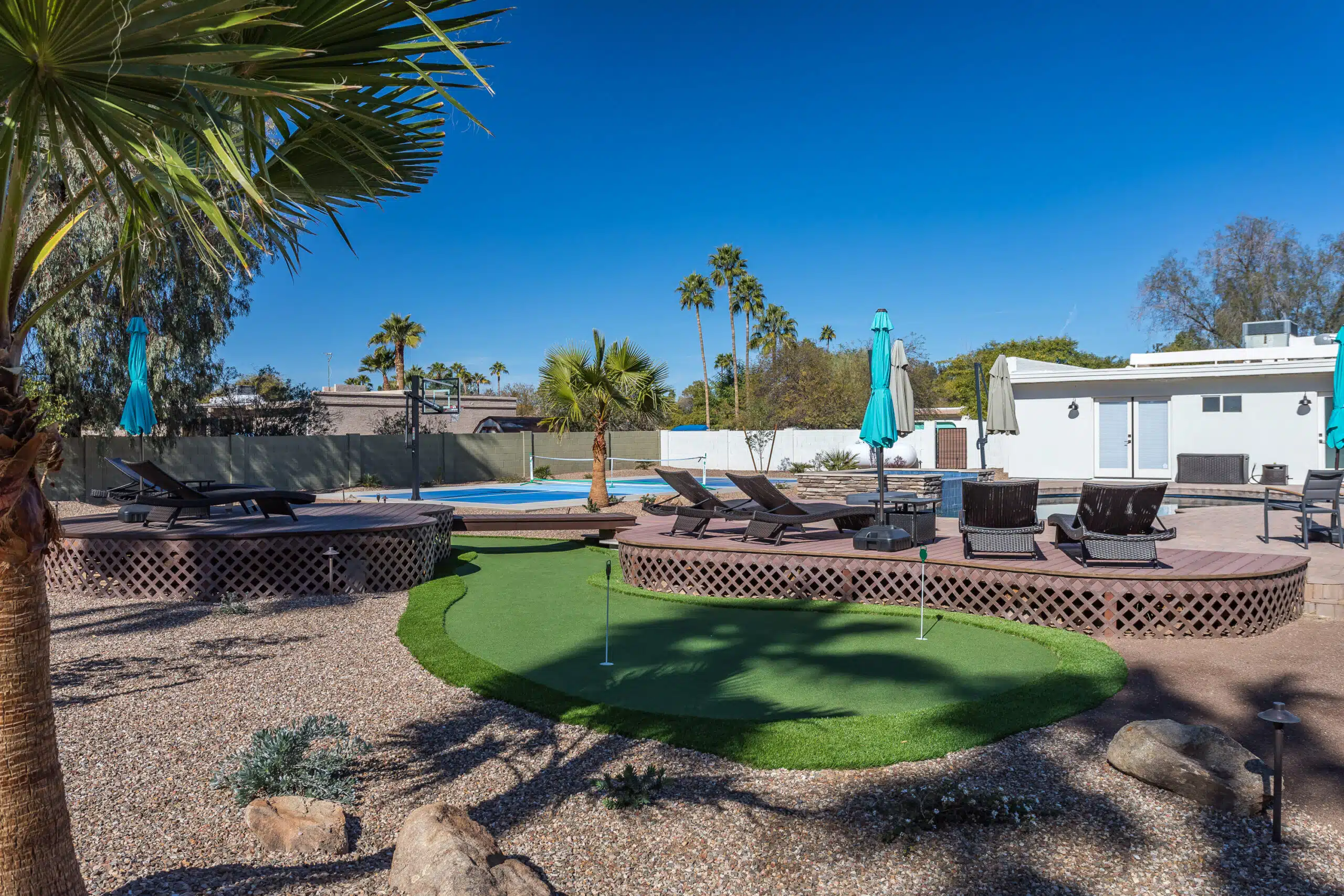 Arizona backyard with pool, lounge seating, deck, and putting green